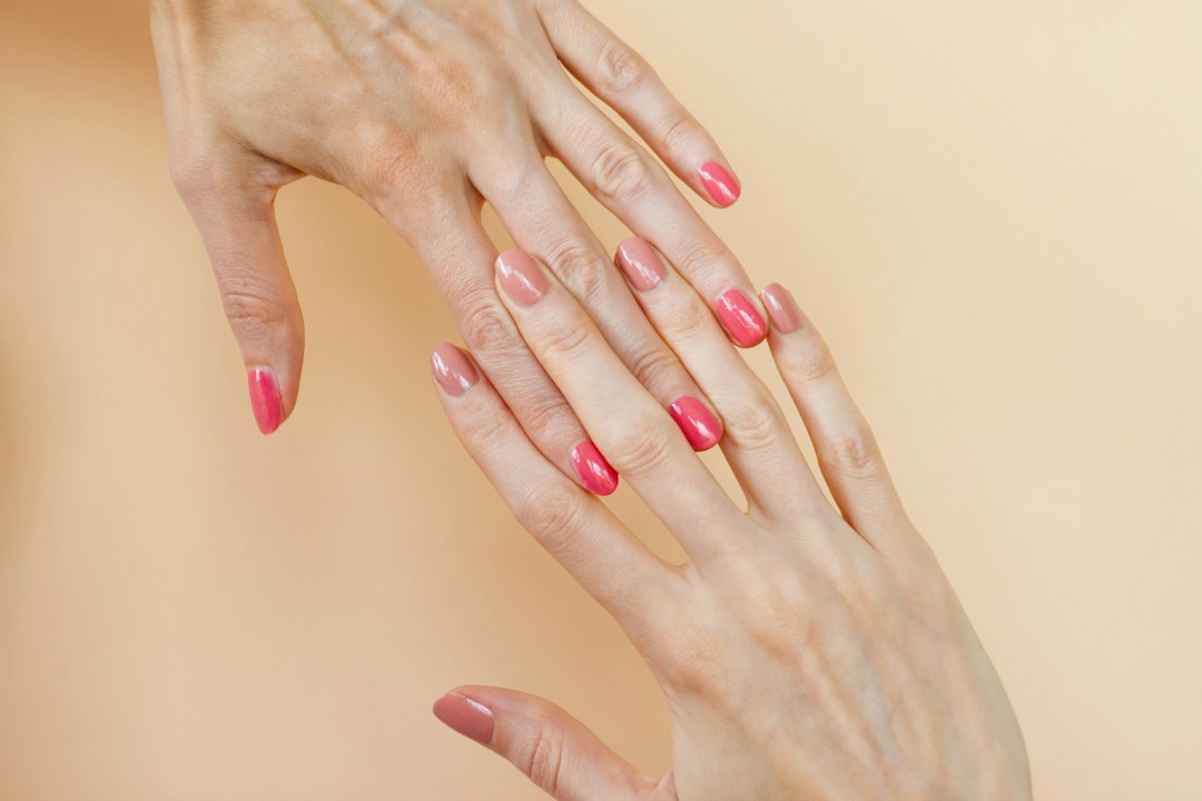 Dwie dłonie z manicure w dwóch odcieniach lakieru - zdjęcie ilustracyjne do poradnika aura nails