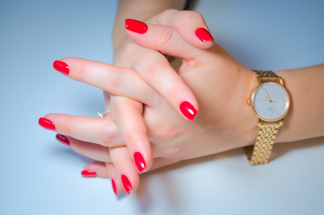 Dłoń z czerwonym manicure i zegarkiem