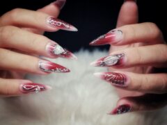 Dłonie z długimi czerwono-białymi paznokciami stiletto