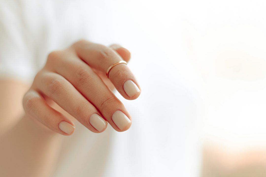 Dłoń z jasnym, gładkim manicure