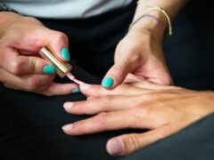 Manicure wykonywany na kolorowych paznokciach dłoni