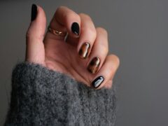 Dłoń ze srebrnym pierścionkiem i czarnym manicure